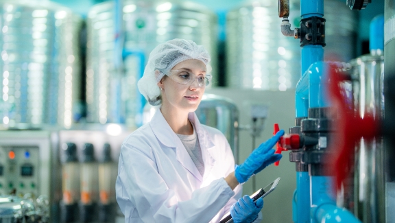 An employee with protective clothing working in a manufacturing plant.