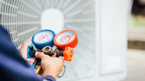 Close up of a person checking the air pressure of the Air Conditioner.