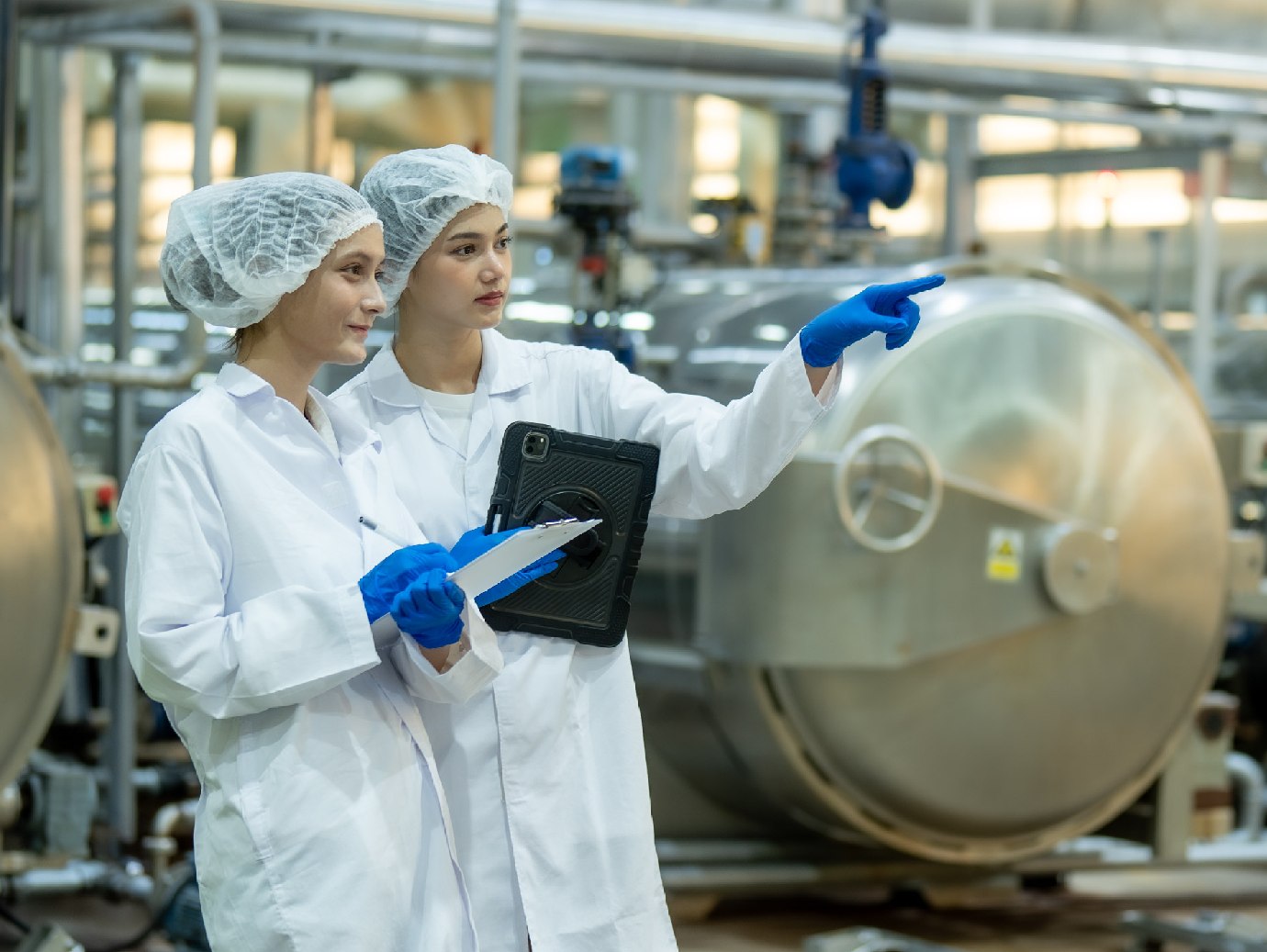 Two scientists discuss as they work in a manufacturing unit.